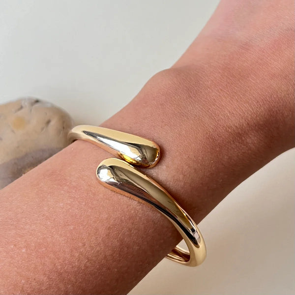 Side view of adjustable gold plated fashion bracelet showing thickness and shine