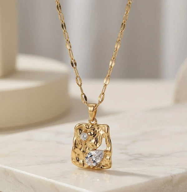 Front view of abstract melted metal gold-plated necklace with crystals by Moncheri