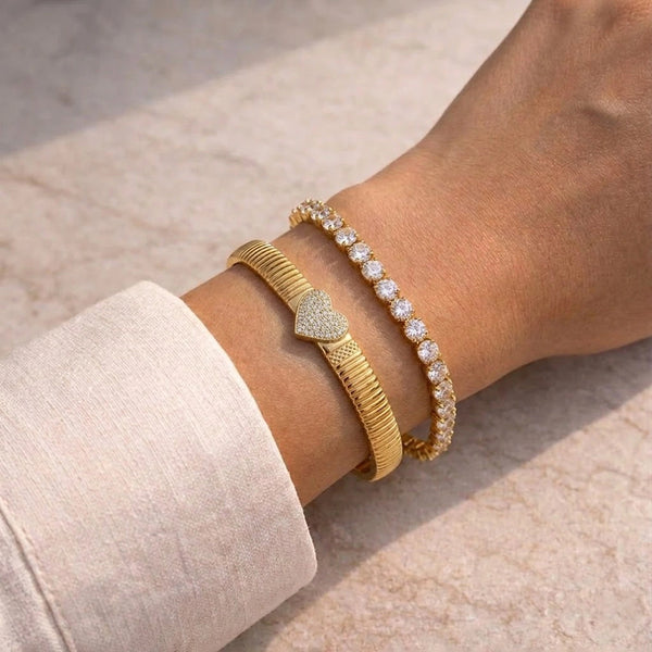 Woman wearing an aesthetic anti-tarnish fashion jewelry stack featuring a sparkling heart bangle and a zircon tennis bracelet.