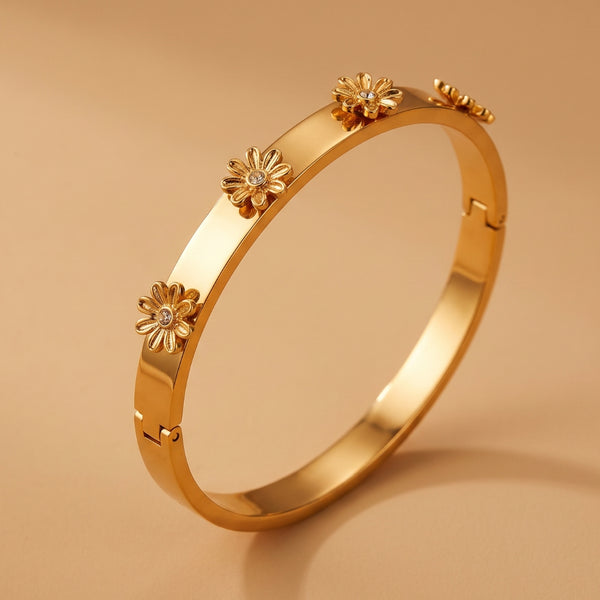 Detailed close-up of the flower design on a gold plated anti-tarnish bangle.