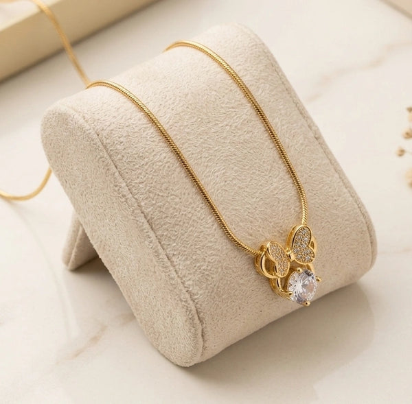 Front view of elegant anti-tarnish gold plated crystal bow pendant necklace