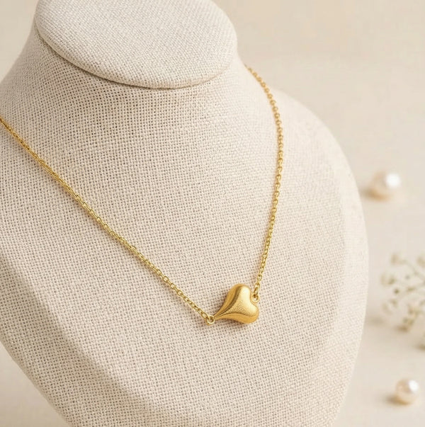 Front view of an elegant anti-tarnish gold plated textured heart necklace on a display bust