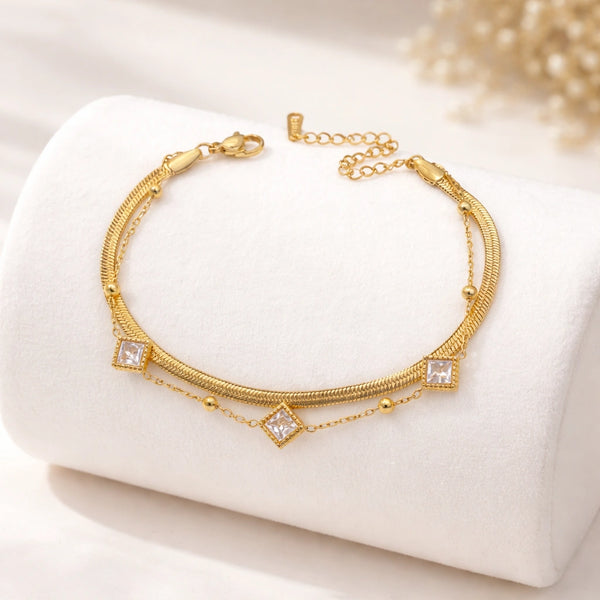 Close up detail of sparkling square crystal charms on an anti tarnish gold plated bracelet