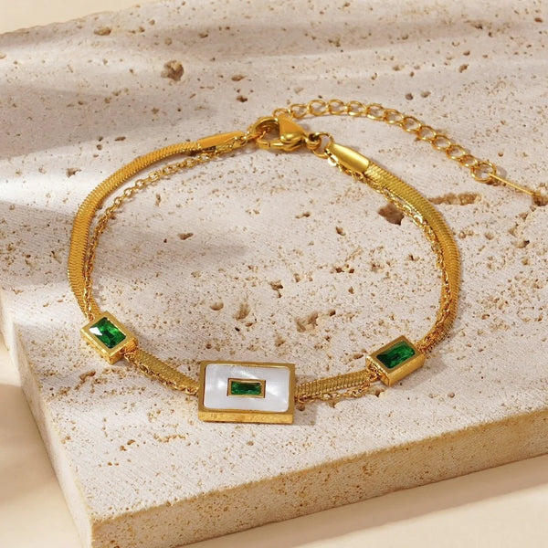 Flatlay of hypoallergenic stainless steel gold bracelet with green stones