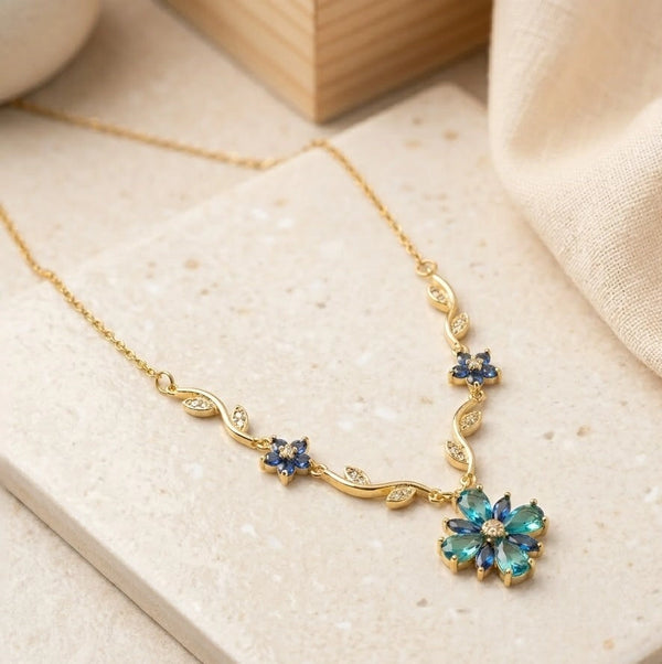 Front view of blue crystal floral vine anti tarnish gold plated necklace