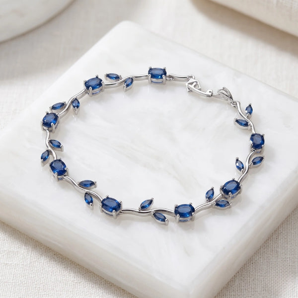 Blue Sapphire Floral Vine Design Bracelet on White Marble Backdrop
