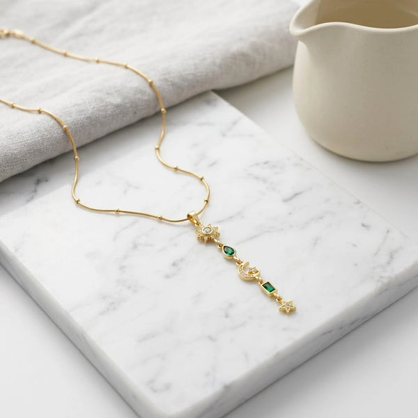 Front view of the celestial sun moon and star drop anti-tarnish gold plated necklace by Moncheri