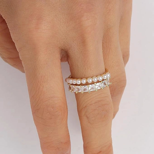 Close up detailing of the sparkling cubic zirconia stones and white pearls on a gold ring