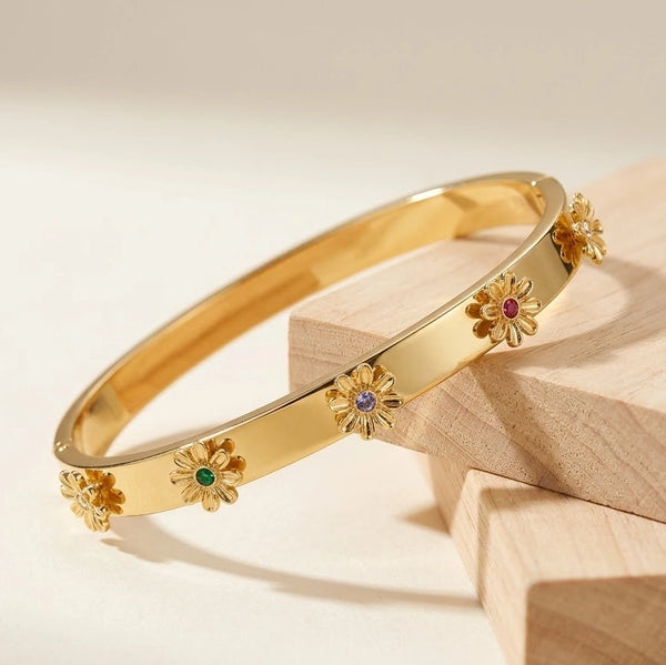 Front view of daisy motif multi-color stone bangle in anti-tarnish gold plating