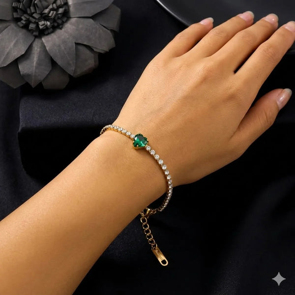 Delicate gold-plated jewelry bracelet with clear diamonds and a green heart centerpiece