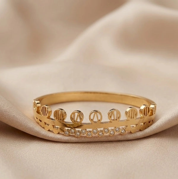 Elegant layered bangle bracelet styled on cream silk background