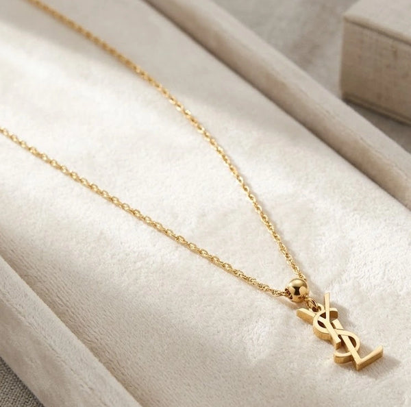Woman wearing interlocking letter pendant necklace with blue blazer for office wear