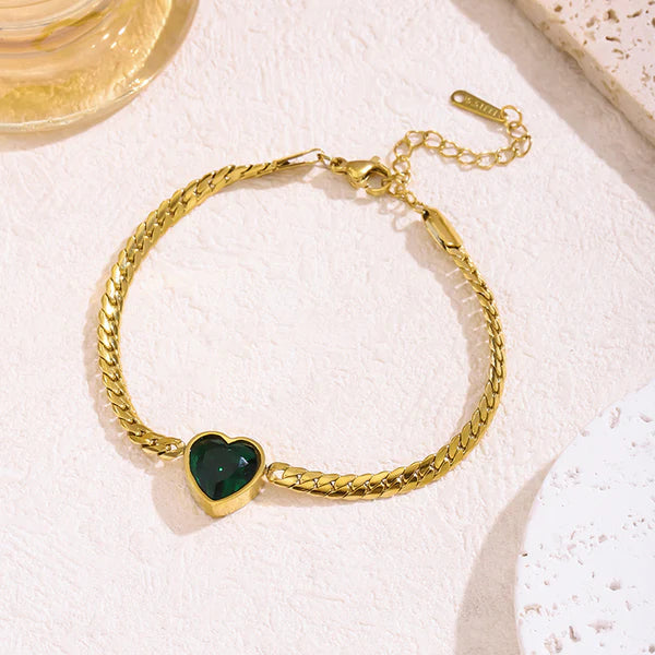 Emerald green heart gold plated chain bracelet on a white cushion