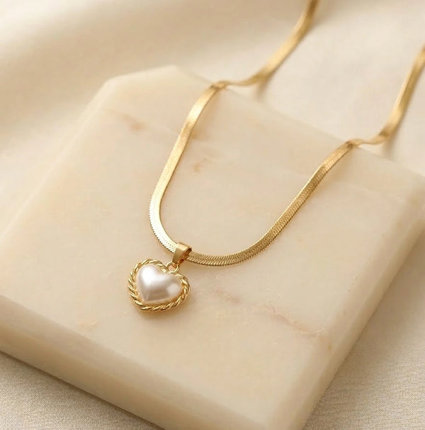 Front view of anti-tarnish gold-plated snake chain necklace with pearl heart pendant on marble display