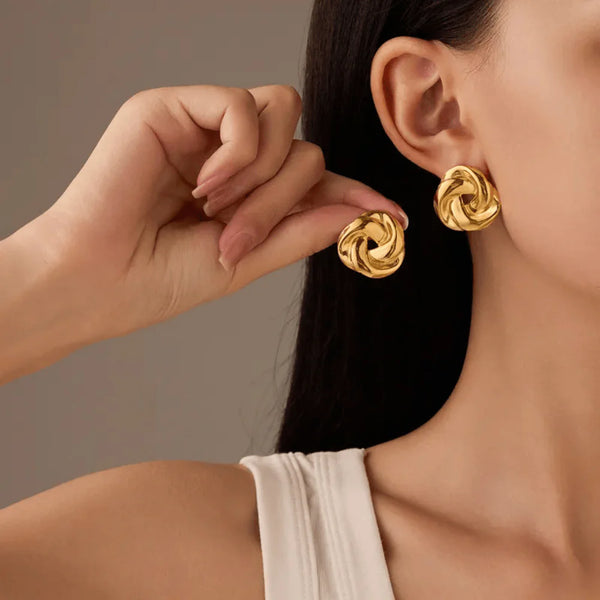Woman wearing statement gold knot earrings western style for office look