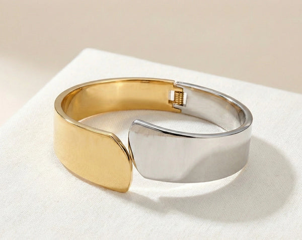 Close-up of a Korean-style two-tone bangle showcasing its unique overlapping asymmetrical design and high-gloss polish