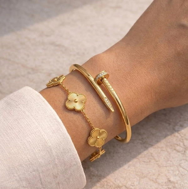 Moncheri gold-plated Korean style clover charm bracelet resting on a premium jewelry box.