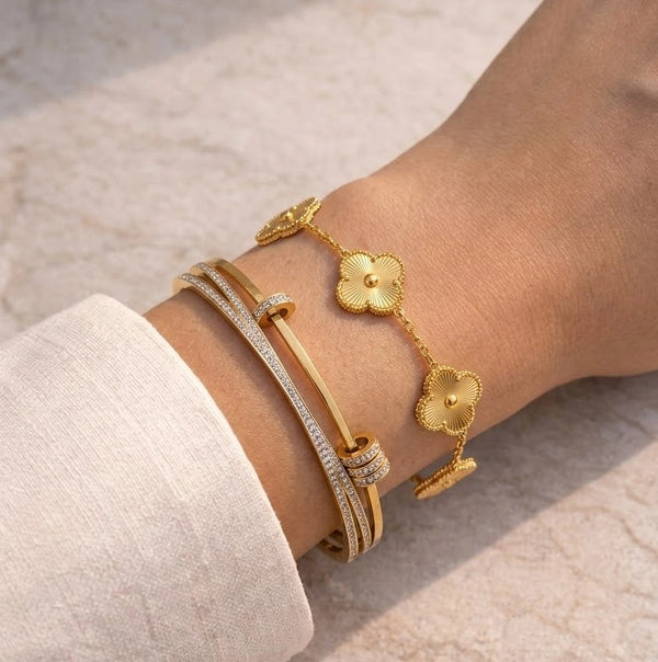  Moncheri 18k gold-plated vintage clover charm bracelet resting on a display box