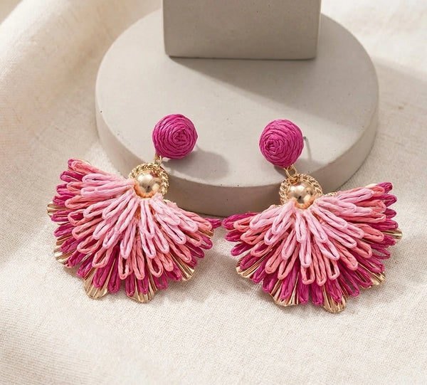 Front view of pink bohemian woven fan tassel statement earrings