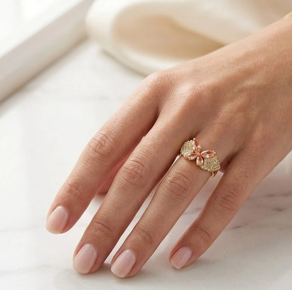 Close up details of sparkling clear and peach crystals on fashion ring