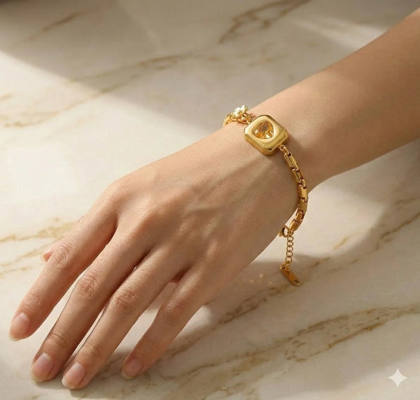 Close up of the sparkling heart design inside a square frame on a gold plated anti tarnish bracelet.