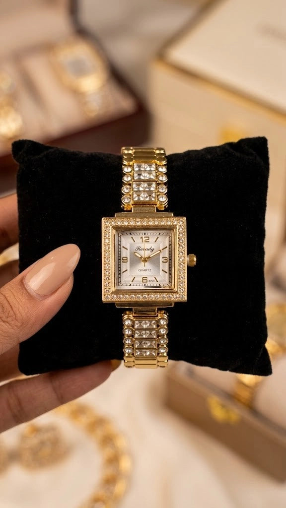 Woman holding a vintage square gold watch with a rhinestone bezel against a neutral, soft aesthetic background