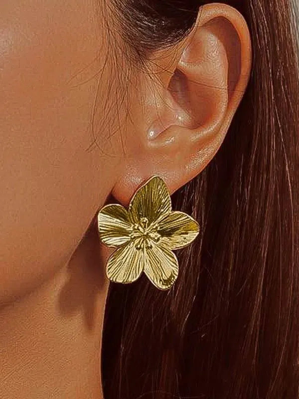 Close up of textured gold petals on hypoallergenic floral earrings.