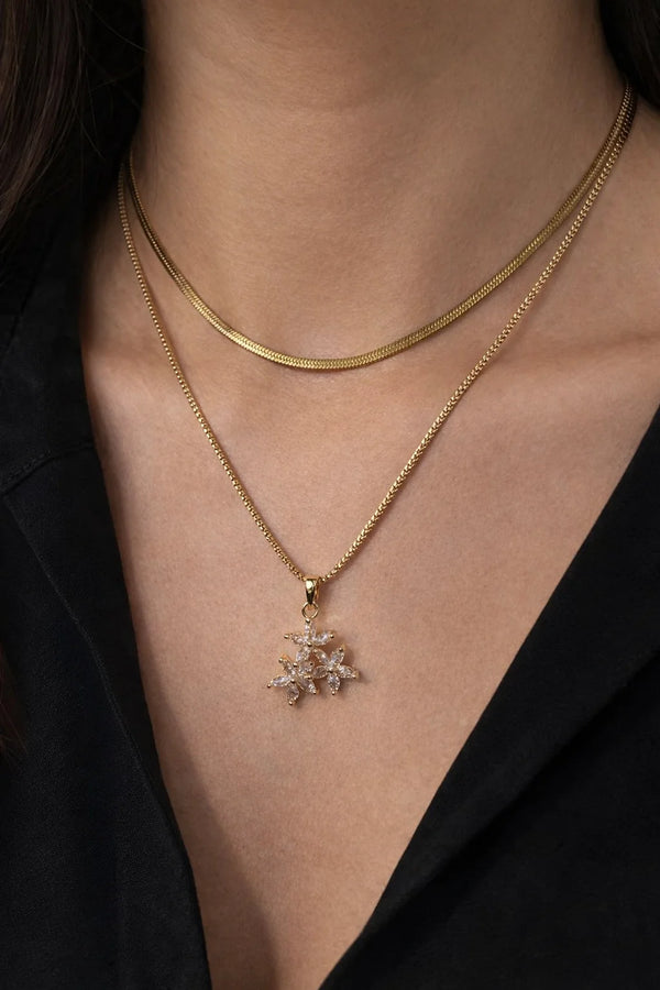 Close up detail of sparkling zircon crystal flower pendant on gold chain